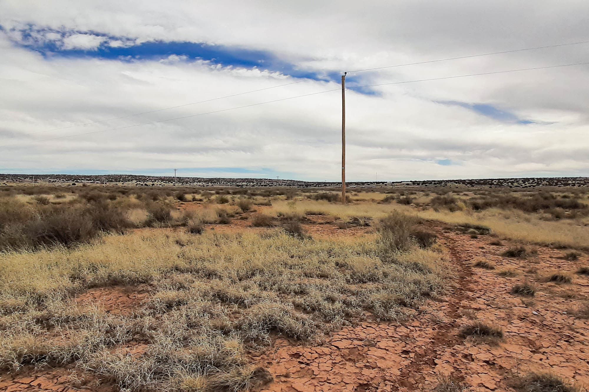 Ground-level view looking northwest from the southeast corner across scattered sagebrush in Apache County, Arizona.