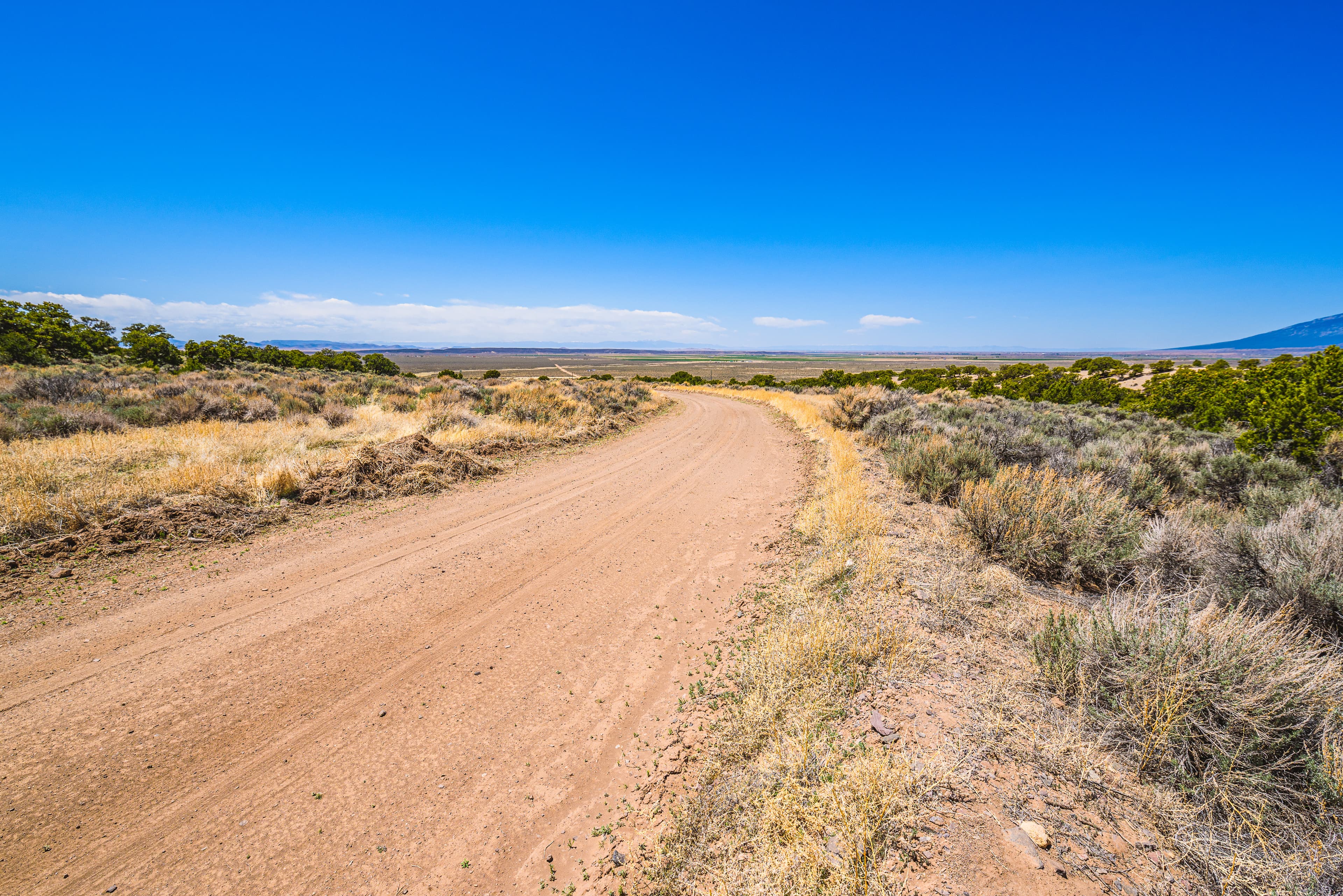 Access road extending westward from the southwest corner through sagebrush in Costilla County, Colorado.