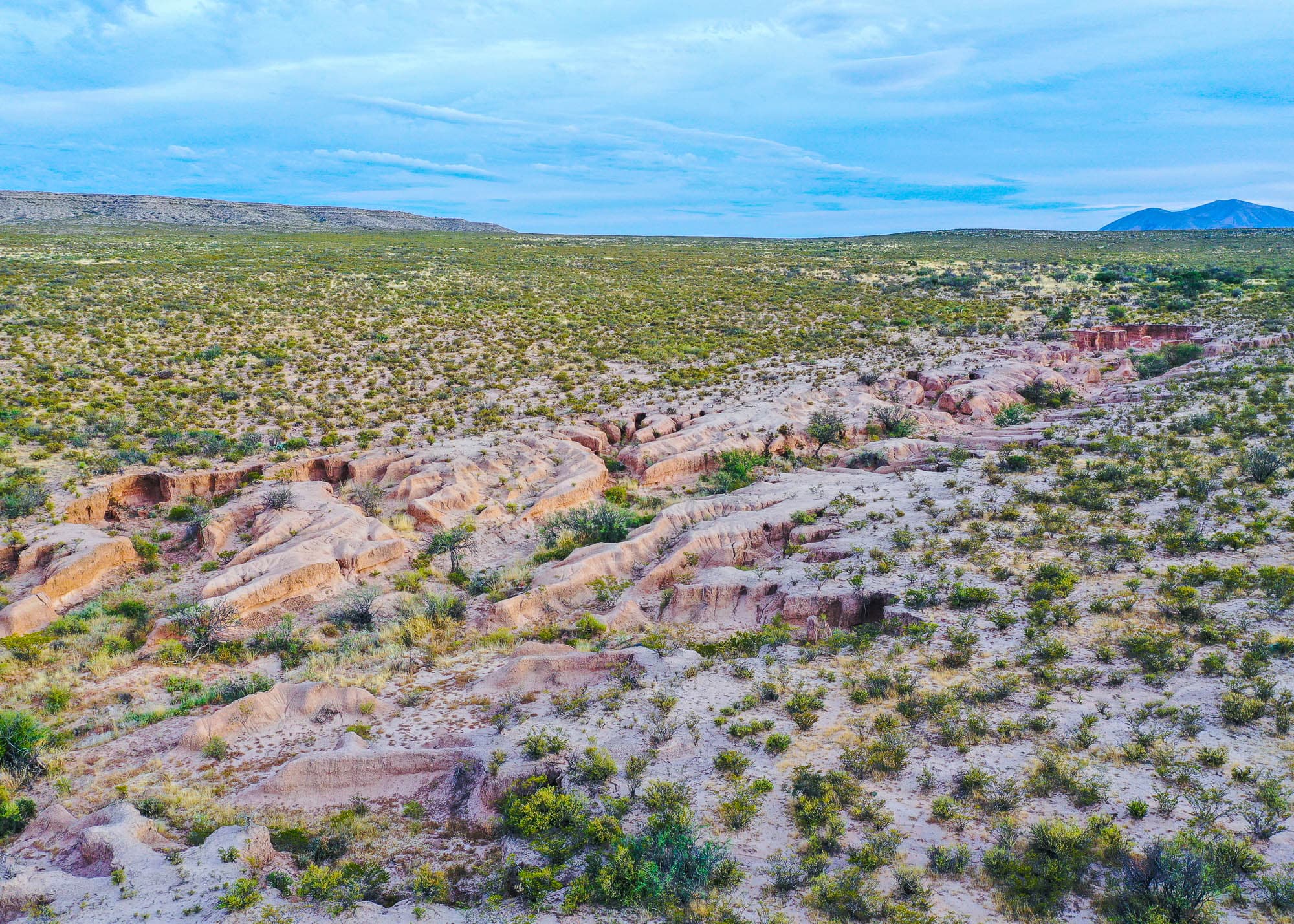 Reddish-brown stone formations and open scrubland across the 5.14-acre property in Hudspeth County, Texas.