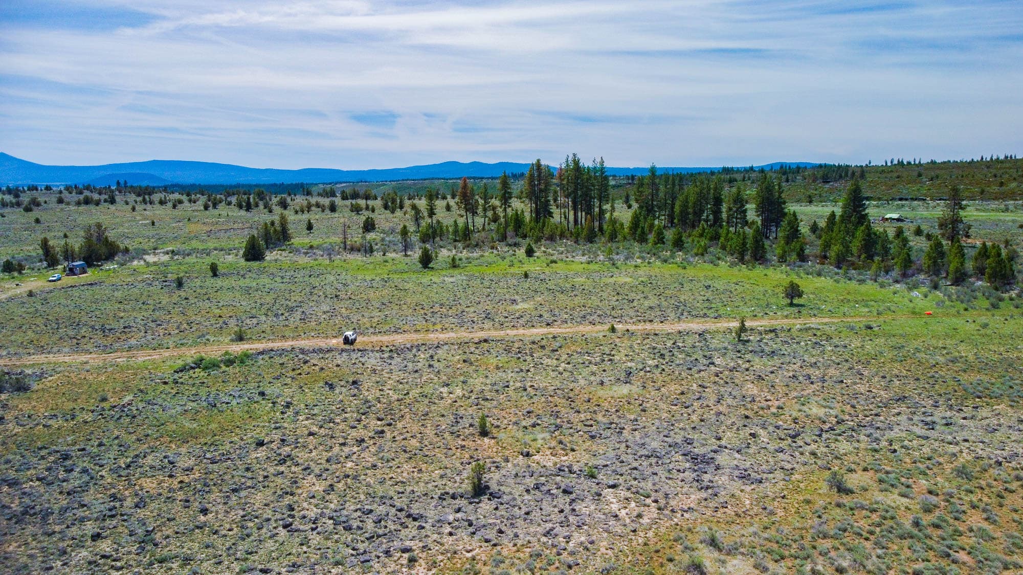 Aerial photo of 1.51 acres with sparse young trees and volcanic rock scattered across sagebrush in Klamath County, Oregon.